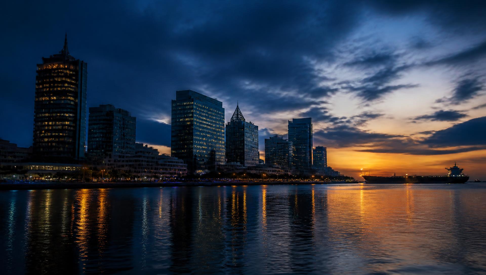 Corporate waterfront skyline at dusk with an oil tanker on the horizon